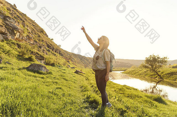 旅行者女人背包景观视图自然绿色场日落旅游概念