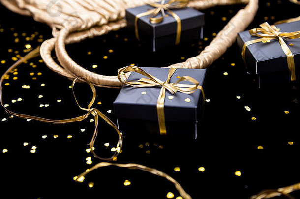 黑色的礼物盒子黄金丝带流行金袋发光背景