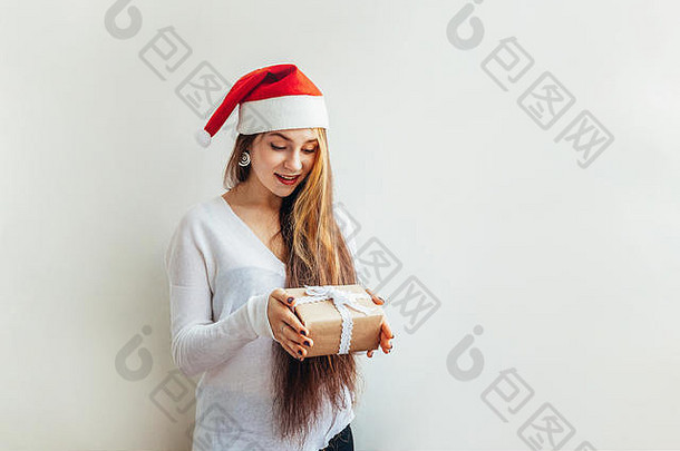 美丽的女孩长头发红色的圣诞老人老人他持有礼物盒子孤立的白色背景快乐兴奋年轻的女人肖像真正的情绪快乐圣诞节一年假期