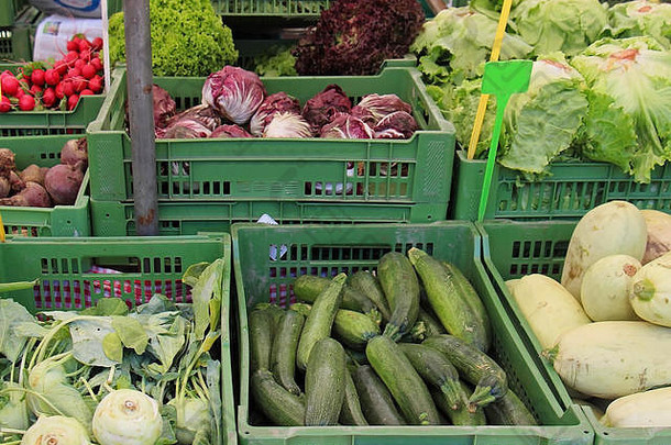新鲜的有机蔬菜桩内部绿色塑料板条箱出售市场摊位