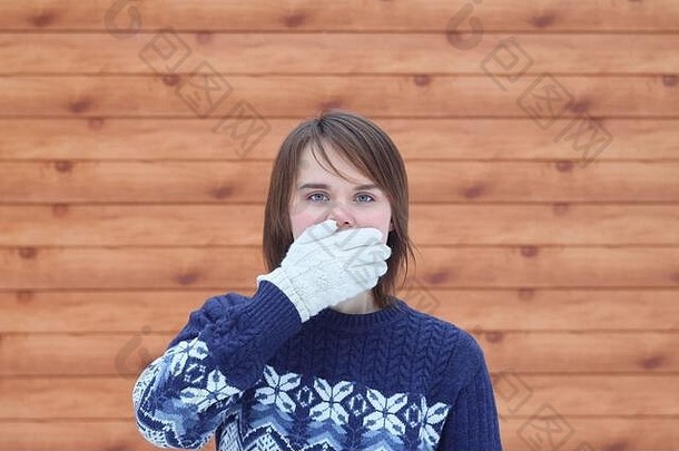 年轻的可爱的美丽的女孩毛衣背景木板路涵盖了口棕榈手白色手套