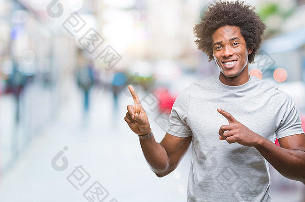 非洲式发型美国男人。孤立的背景微笑相机指出手手指一边