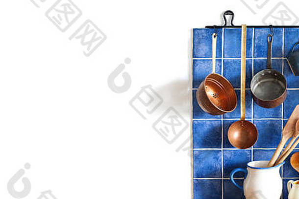 厨房室内古董铜餐具风格炊具厨房用具集锅厨房勺子除油船挂蓝色的瓷砖墙复制空间白色背景