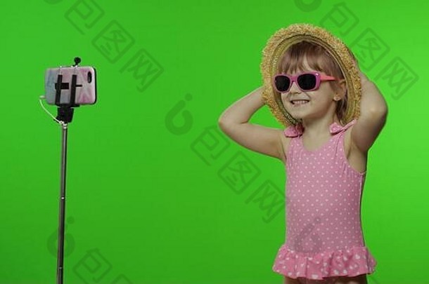 女孩孩子使自拍视频博客写博客移动电话独脚架孩子粉红色的泳装他太阳镜智能手机视频调用记录假期海概念浓度关键