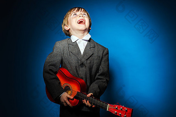 红发学龄前儿童男孩乌卡莱莱孤立的蓝色的音乐概念