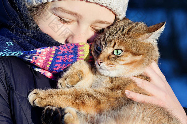户外肖像快乐青少年女孩持有红色的猫冬天场景