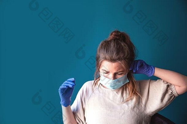 年轻的女人穿保护手套脸面具内部首页检疫无聊伤心科维德冠状病毒蓝色的背景