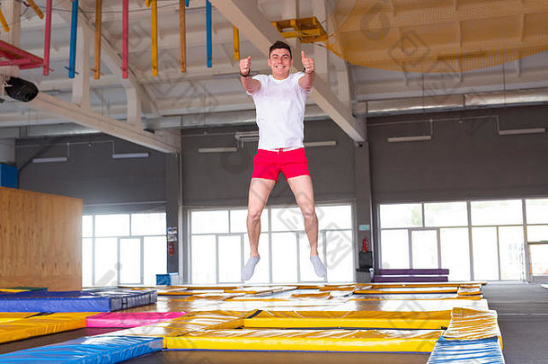 <strong>健身</strong>有趣的休闲体育运动活动概念英俊的快乐男人。跳蹦床在室内