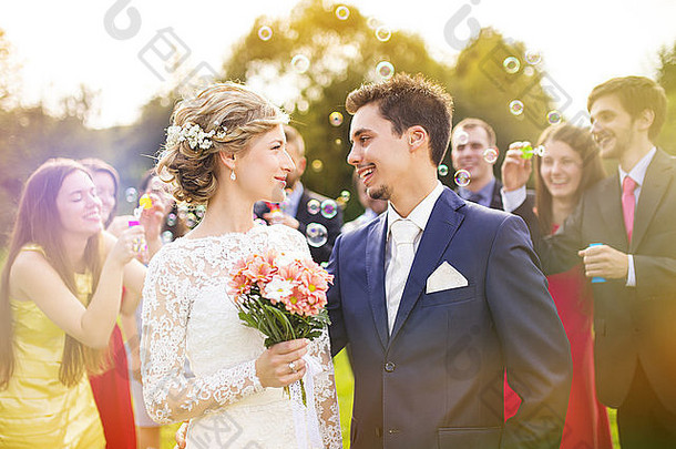 年轻的新婚夫妇享受<strong>浪漫</strong>的时刻婚礼接待婚礼客人背景吹泡沫
