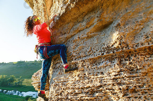 照片卷曲的浅黑肤色的女人<strong>登山</strong>者攀爬岩石