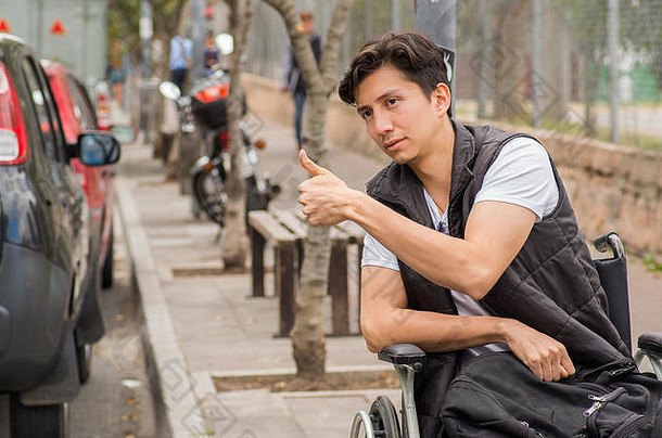 关闭英俊的伤心年轻的禁用男人。轮椅手出租车基多(Quito)城市