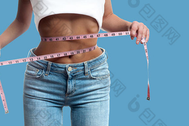 饮食概念女人测量腰重量损失柔和的蓝色的背景
