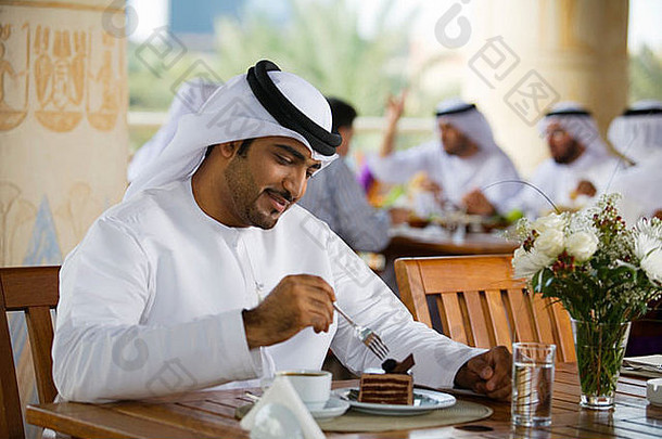 阿拉伯男人。吃甜点咖啡馆
