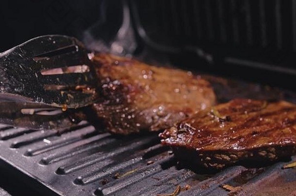 美味的多汁的肉牛排烹饪烧烤岁的主要的罕见的烤烧烤大理石牛肉电烘烤器迷迭香黑色的胡椒盐厨房钳