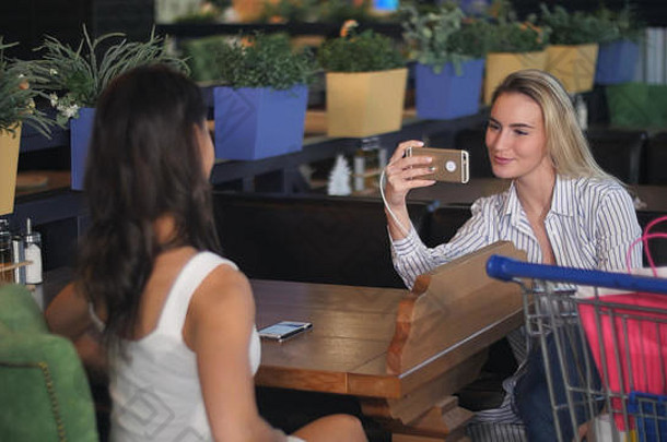 年轻的女人照片朋友购物中心智能手机