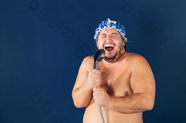 有趣的脂肪男人。蓝色的帽唱淋浴