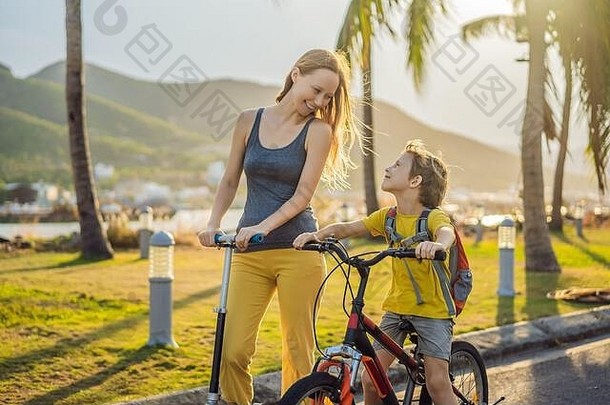 活跃的学校孩子男孩妈妈骑自行车背包阳光明媚的一天快乐孩子骑自行车<strong>学校安全</strong>孩子们在户外学校