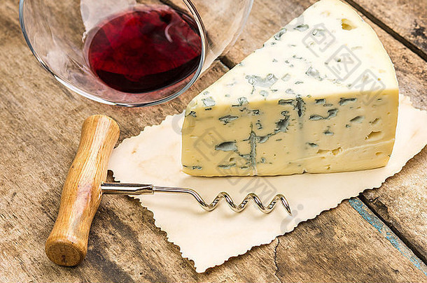 关闭图像一块蓝色的奶酪推翻了葡萄酒杯螺旋木背景
