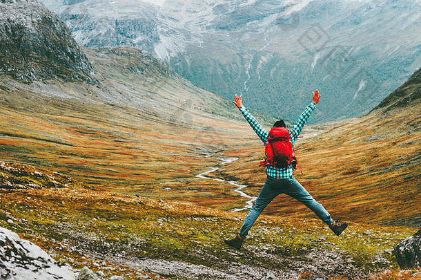 跳男人。背包手提高了山景观背景生活方式旅行快乐情绪成功动机概念斯堪的那维亚牛