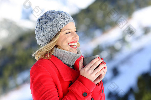 肖像快乐女人穿红色的外套加热杯热咖啡雪山冬天