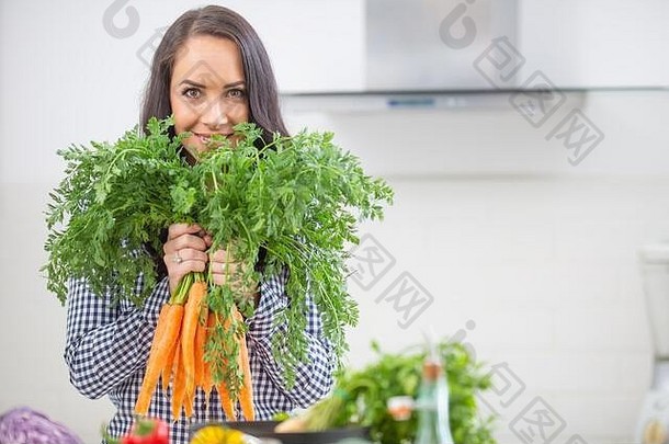 好玩的年轻的女人厨房持有新鲜的胡萝卜手饮食蔬菜希斯概念
