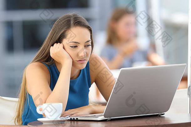 无聊女人看行内容移动PC坐着酒吧阳台