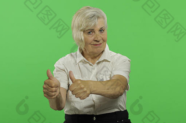 上了年纪的女人显示拇指微笑漂亮的祖母白色衬衫的地方标志文本浓度关键绿色屏幕背景