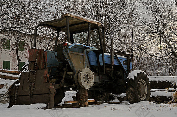 被遗弃的拖拉机轮雪冬天