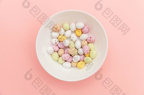 快乐复活节概念准备假期复活节糖果巧克力鸡蛋果冻豆糖果孤立的时尚的柔和的粉红色的背景简单的极简主义平躺前视图复制空间
