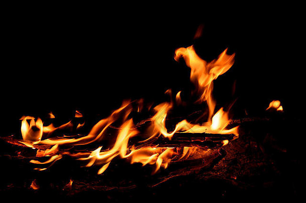 黄色的红色的橙色喷火焰煤炭柴火火篝火黑色的背景