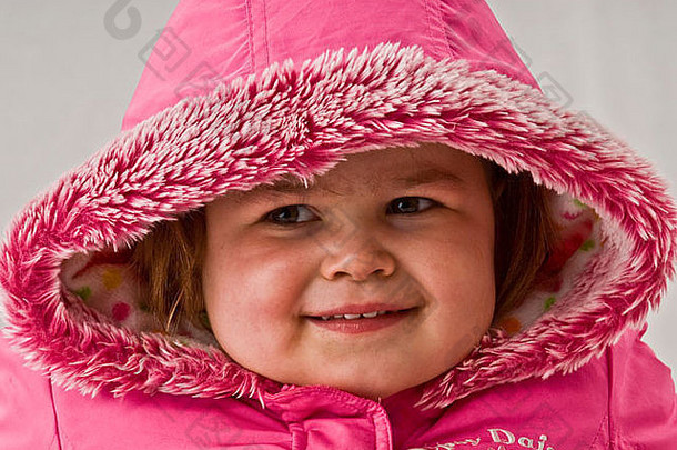 特写镜头可爱的女孩穿红色的冬天派克大衣夹克毛茸茸的小幅罩表达幸福迷人的微笑