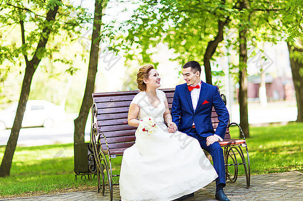 浪漫的婚礼夫妇坐着板凳上春天公园