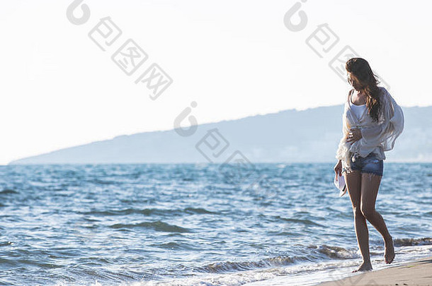 年轻的女<strong>享受阳光</strong>明媚的一天热带海滩