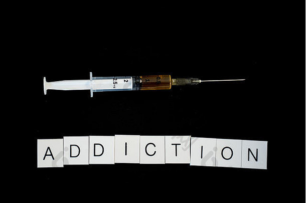 词上瘾大写字母信注射器完整的药物黑色的背景