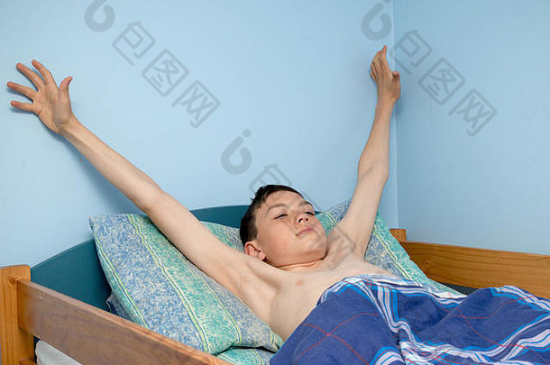 年轻的高加索人十几岁的男孩醒着的床上