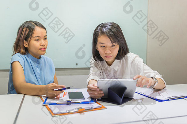年轻的亚洲办公室员工<strong>工作</strong>平板电脑