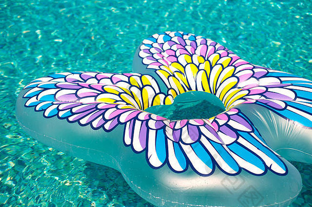 色彩斑斓的膨胀的蝴蝶浮动让人耳目一新蓝色的游泳池