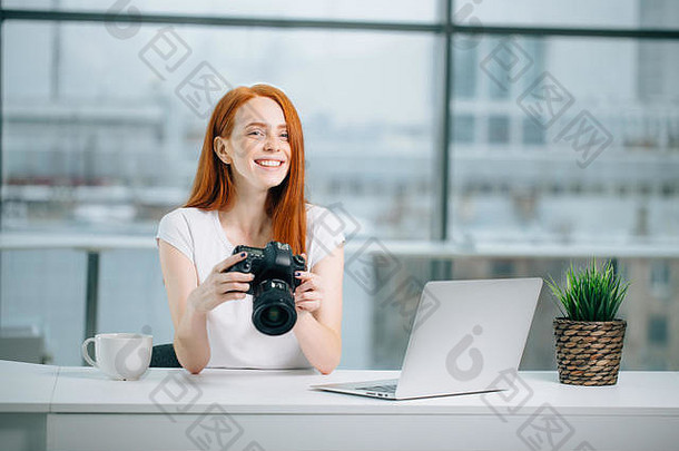 红色头发的人女孩摄影师查看图片相机