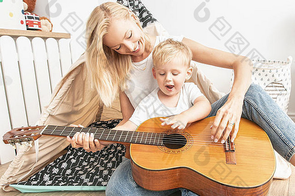 妈妈。孩子玩孩子们房间妈妈儿子使音乐吉他休闲时间首页家庭幸福爱
