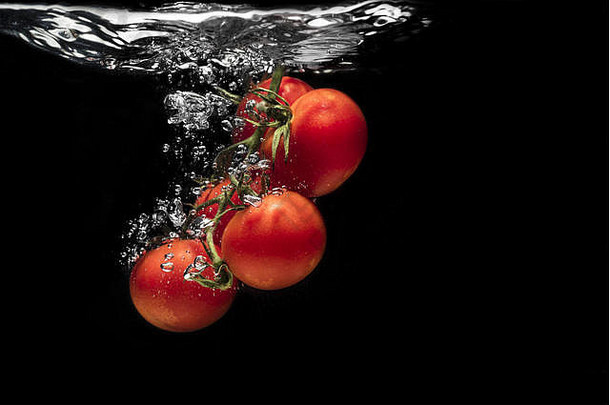 高速度摄影番茄飞溅水孤立的<strong>黑</strong>色的背景