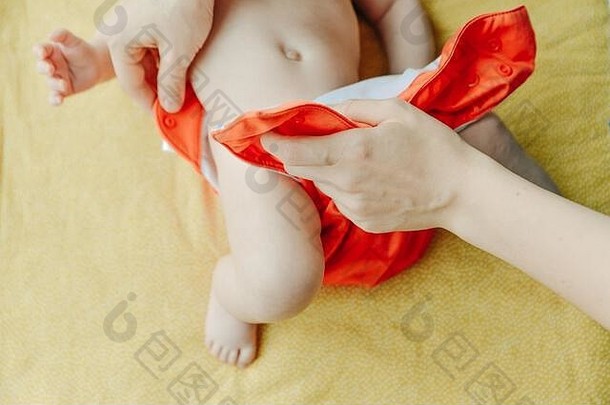 关闭妈妈。手把婴儿橙色尿布新生儿