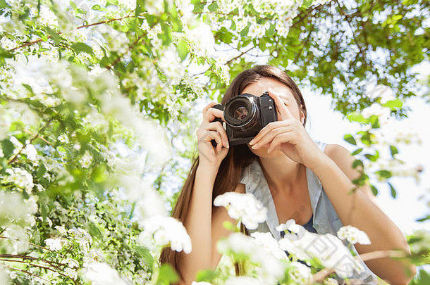 女业余摄影师采取照片花复古的相机夏天公园美丽的阳光明媚的一天
