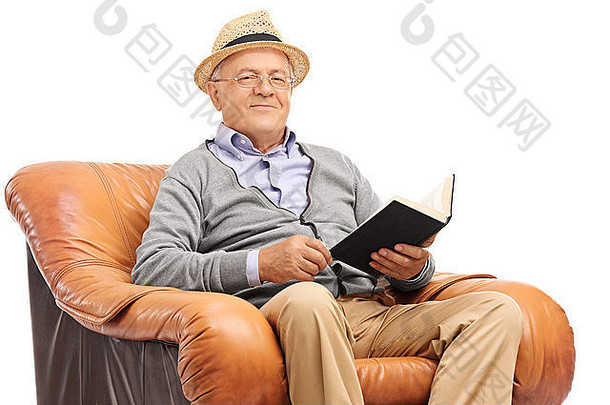 高级绅士持有书坐着扶手椅相机孤立的白色背景