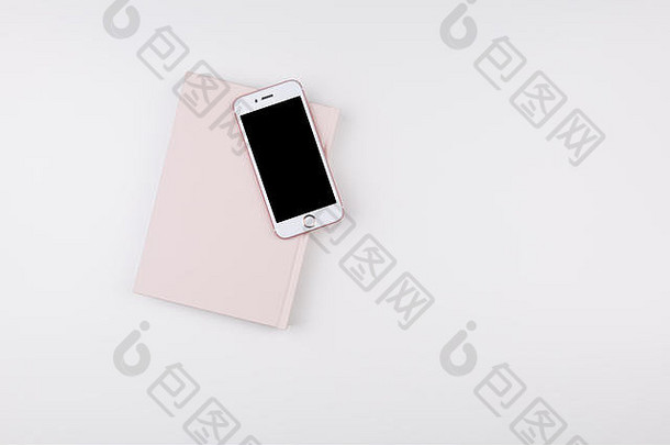 粉红色的笔记本聪明的电话白色桌子上平躺作文前视图