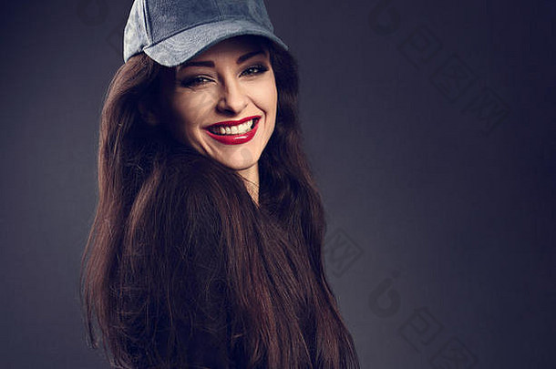 兴奋微笑美丽的浅黑肤色的女人女人棒球蓝色的帽长头发风格黑暗影子背景健美的特写镜头肖像