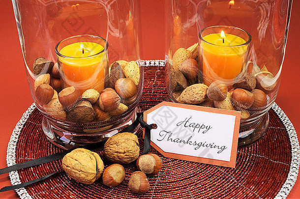 美丽的快乐感恩节表格设置核心橙色蜡烛坚果装饰玻璃飓风灯花瓶