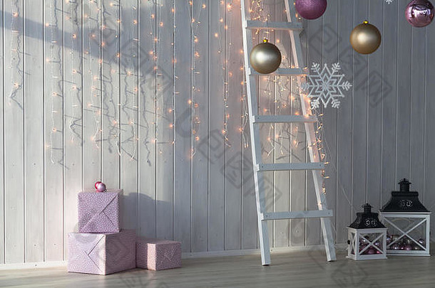 圣诞节灯燃烧白色木背景粉红色的giftboxes楼梯