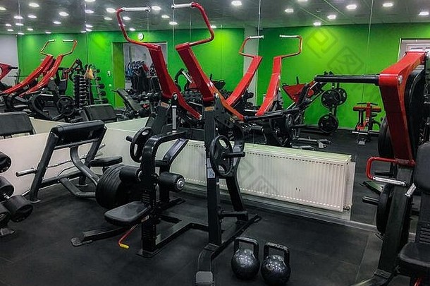 健身房健身大厅室内设备机器杠铃棒磁盘重量哑铃体育运动健身生活方式人概念
