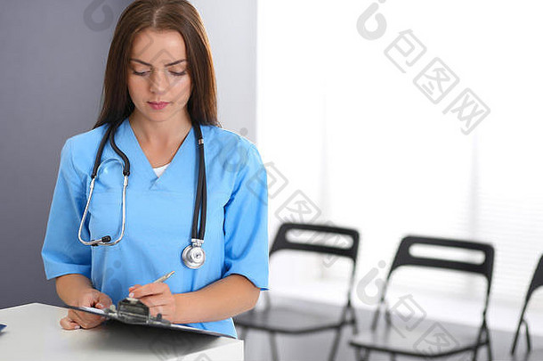 医生女人工作肖像女医生填充医疗形式站接待桌子上诊所紧急医院医学医疗保健概念