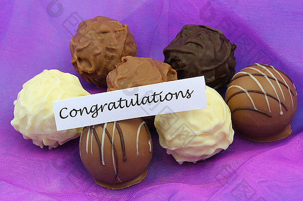 祝贺你卡各种各样的巧克力果仁糖松露紫色的背景